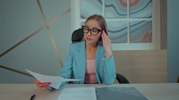 Biznes Kobieta Niebieskim Garniturze Siedzi Przy Biurku Zdjąć Okulary Czytanie — Wideo stockowe