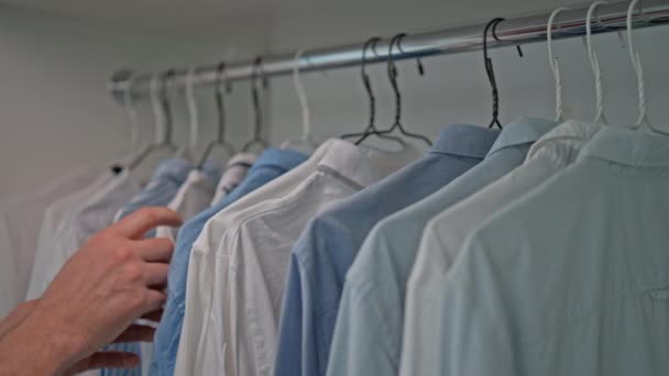 Samec Vybere Oblečení Obchodě Pohybující Rukou Různých Košilích Stojanu — Stock video