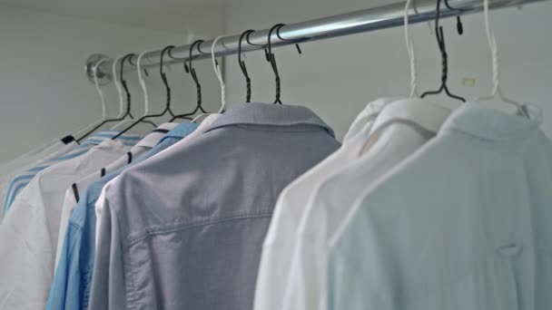 Женщина Организует Мужскую Вешалку Формальной Одеждой Сине Белые Рубашки Магазин — стоковое видео