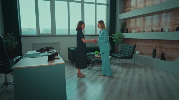 オフィスで会う2人の女性握手ブルネットの女性が仕事の面接に来るフレンドリーな雇用主は従業員を迎える — ストック動画