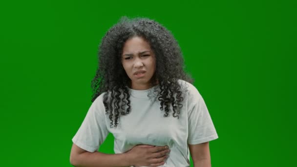 長い髪の女性が腹部の痛みに苦しんで白いシャツを身に着けている緑の画面に隔離 — ストック動画