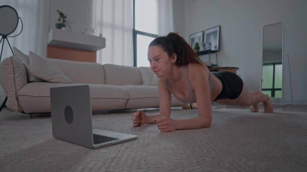Woman Wearing Sports Clothes Doing Plank Exercise Watching Display Laptop — Stock Video