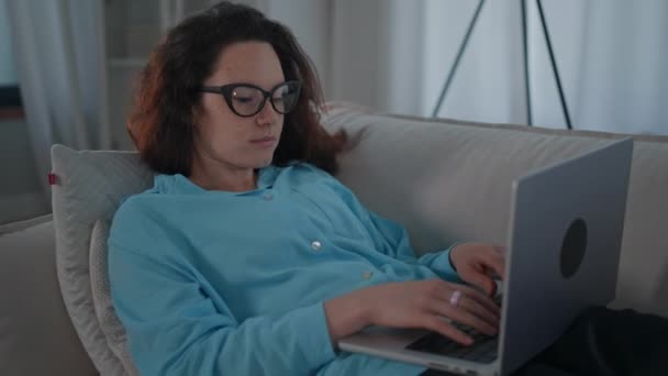 Mulher Cabelos Vermelhos Usando Óculos Trabalha Casa Digitando Laptop Conversando — Vídeo de Stock