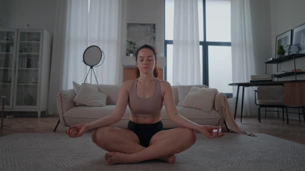 Oturan Çapraz Bacaklı Yoga Pozu Veren Spor Elbiseli Kadın Yerde — Stok video