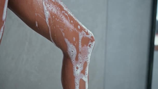 Close Woman Washing Legs Holding Pink Wisp Bast Foam Pouring — Stock Video