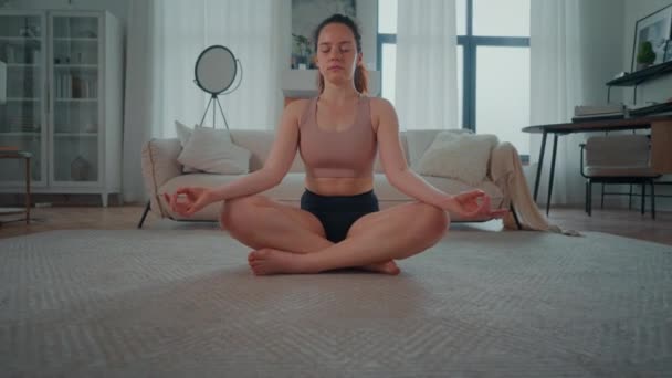 在客厅里 人们看到一个女人坐在瑜伽位置上 专注于呼吸和保持适当的体形 视频剪辑