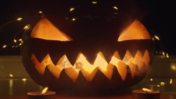 南瓜一种雕刻的南瓜 有一张恐怖的脸 里面闪烁着蜡烛 蜡烛发出一种令人生畏的光芒 凸显了南瓜雕刻的复杂细节 图库视频片段