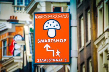 Amsterdam 'daki bir Hollanda sokak tabelasında parlak turuncu arka planda beyaz bir mantar yer alır. Mantarın altında 