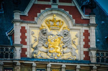 Amsterdam Centraal İstasyonunda Hollanda arması bulunmaktadır. Taçlı bir aslan gururla durur, elinde bir kılıç ve yedi ok vardır. Bu sembol hem Hollanda monarşisini hem de