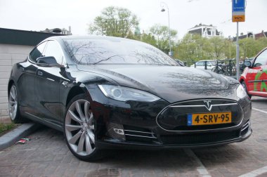 Amsterdam 'da park etmiş siyah bir Tesla Model S. Bu şık elektrikli araba Tesla ya da S Modeli için bir reklam olabilir..