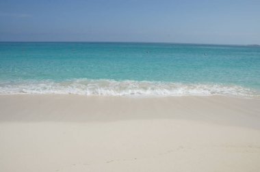 Kumsal. Beyaz kum turkuaz suyla buluşur. Sakin dalgalar kıyıya vurur. Huzur. Kaçmak. Bahamalar.