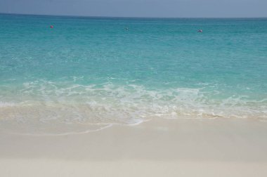 Kumsal. Beyaz kum, turkuaz suyla nazik dalgalarla buluşur. Idyllic tropik cennet. Günlük hayattan kaçmak. Bahamalar. Kumsal. Beyaz kum, turkuaz suyla nazik dalgalarla buluşur. Idyllic tropik