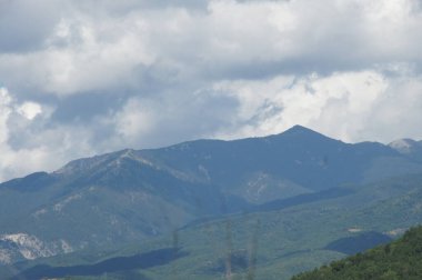 Dağ sırası, Bulgaria. Bulutlu bir gökyüzüne doğru yemyeşil yamaçlar yükseliyor, BULGARIA. Sis ile kaplanmış uzak tepeler, BULGARIA. Sonsuzluk ve dinginlik hissi, BÜLGARYA. Doğanın ihtişamının bir hatırlatıcısı,