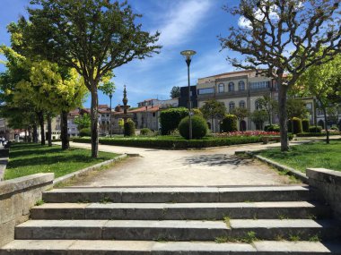 Taş basamaklar, yemyeşil parkın asfalt yoluna çıkıyor. Büyüleyici binalar manzaralı değil. Braga, Portekiz. Huzurlu şehir inzivası şehir gürültüsünden kaçış sunuyor.