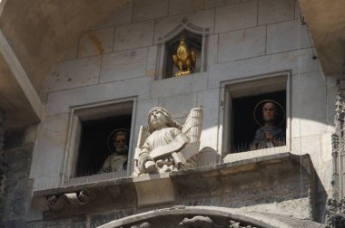 Prag Astronomik Saati, bir ortaçağ başyapıtı, azizlerin ve meleklerin heykelleriyle süslenmiş. Rakamlar 12 Havari ve diğer önemli dini figürleri sembolize ediyor. Saat gösteriyor ki