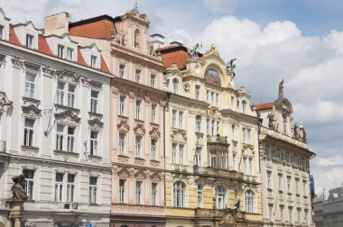 Prag 'daki Old Town Meydanı. Renkli Barok binaları meydanı kaplar, yüzleri karmaşık detaylarla süslenir ve üstü kırmızı kiremit çatılarla kaplanır. Astronomik Saat, Çek tarihinin bir sembolü.