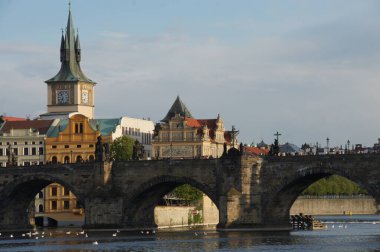 Charles Bridge, Çek Cumhuriyeti. Vltava Nehri 'ni kaplayan birden fazla kemerli taş köprü. Prag 'ın zengin tarihinin bir sembolü olan ufuk çizgisine ortaçağ mimarisi hakim. Kuğular huzur içinde yüzerler.