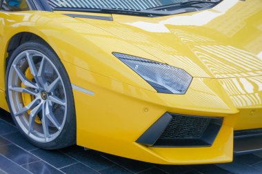 Dubai 'de, parlak sarı bir Lamborghini Aventador, hız ve performansıyla tanınan lüks bir araba, bir binanın önündeki fayanslı zeminde parlıyor..