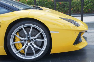 Dubai 'deki yakın plan çekimde sarı Lamborghini Bulvarı S. Çöl güneşinde parlayan kaputun üzerindeki siyah ve gümüş Lamborghini logosu ortaya çıktı. Bu parlak, güçlü makine potansiyel bir makine.