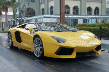 Dubai 'de, parlak sarı bir Lamborghini Bulvarı modern cam gökdelenin önünde güçlü bir motor parıldıyor..
