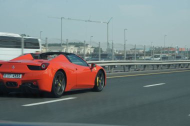 Kırmızı bir Ferrari 458 Örümcek bir Dubai otobanını yıktı. Gösterişli spor araba, açık yolların özgürlüğünü simgeler. Rüya makinesinde heyecan verici hızlı bir sürüş..
