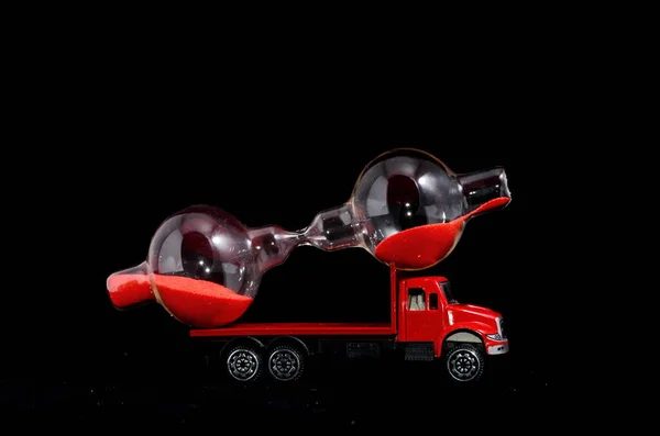 Концепція Перевезення Часу Hourglass Watch Вантажівці Червоної Іграшки Над Чорним — стокове фото