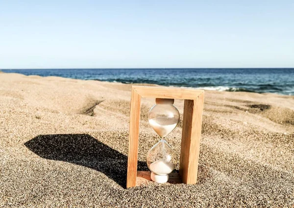 sand clock on beach with sea background