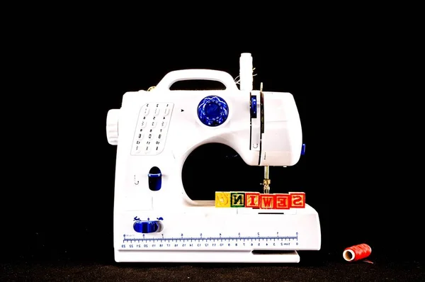 sewing machine with a needle and thread on black background