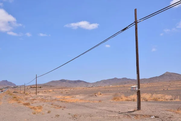 landscape in the desert with rural road and electricity poles