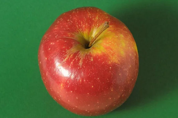 Ein Saftig Roter Apfel Vor Grünem Hintergrund — Stockfoto