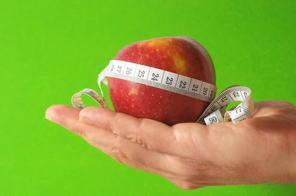 Hand holds apple and meter
