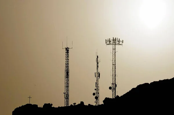 Een Aantal Silhouetted Antennes Top Van Een Heuvel — Stockfoto