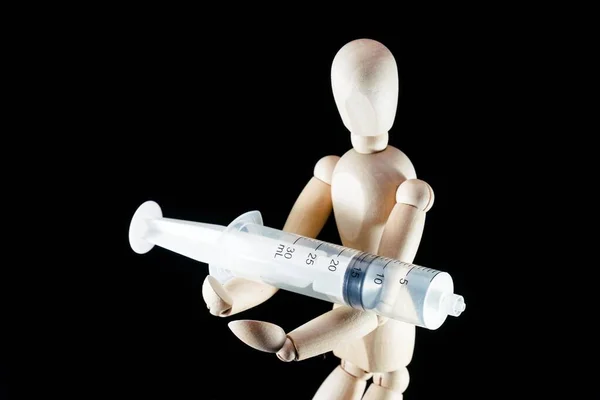 wooden dummy, puppet made of wood, art mannequin with syringe