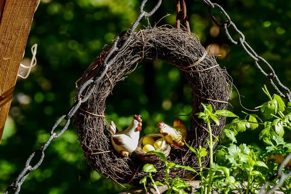 Nest with toy chickens in green garden