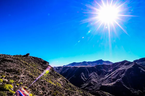 Sun Star on a Blue Sky over a Mountain Silhouette in Gran Canaria Spain