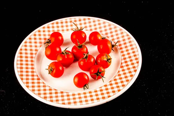 Ein Teller Mit Roten Tomaten Auf Einem Karierten Teller Stockfoto
