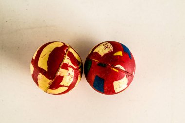 Two balls with red and yellow stripes on them. The balls are placed next to each other on a white surface clipart