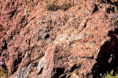 A large, brown rock covered in dirt and debris. The rock appears to be rough and uneven, with some areas looking like they have been weathered by the elements. The dirt on the rock is thick and clumpy clipart