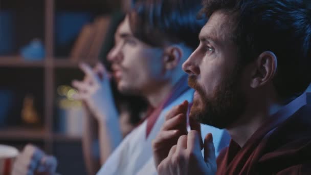 千禧年的人们坐在沙发上等待最受欢迎的足球队胜利 紧张的朋友们用专注的面部表情交叉着手指 为胜利祈祷 — 图库视频影像