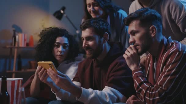 Ομάδα Οπαδών Που Κάθονται Στον Καναπέ Και Παρακολουθούν Ποδόσφαιρο Smartphone — Αρχείο Βίντεο