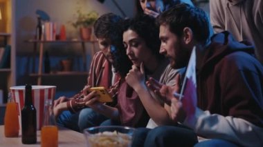 Akıllı telefondan futbol bahislerini takip eden ve favori takımın kazanmasını kutlayan mutlu arkadaşlar. Spor maçı sırasında kanepede oturan arkadaşlar destekliyor. Ortadoğu futbolu kavramı