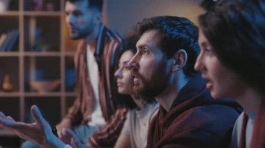 Futbol taraftarları evde kanepede oturup TV 'de yarışma izlerken şampiyonluğu tartışıyorlar. Favori takımı destekleyen ve gol bekleyen insanlar