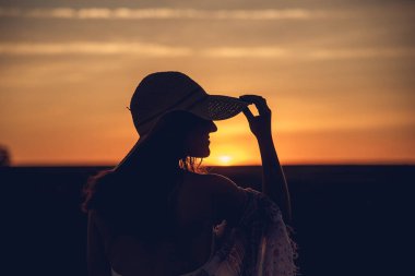 Lavanta tarlasında günbatımında profilde bir kadın.