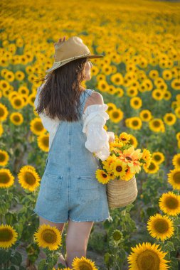 Ayçiçeği tarlasında gölgeli bir kadın