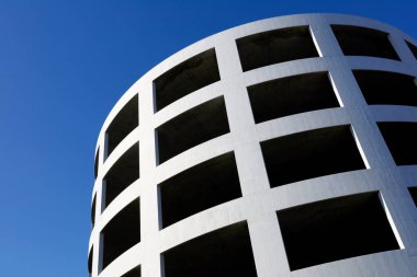 Çok katlı otoparkın ve mavi gökyüzünün spiral eğimi