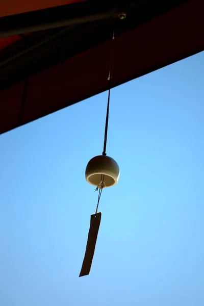 在一家商店的屋檐下悬挂着一种叫做 Furin 的风铃 这是日本的夏季传统 — 图库照片