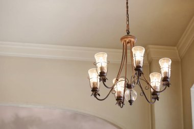 Beyaz duvarlı bir odada antika tarzı avize.