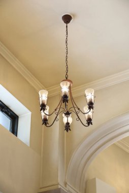 Beyaz duvarlı bir odada antika tarzı avize.