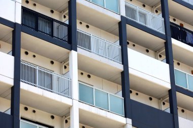 Beyaz ve lacivert renklerin dışındaki modern apartman binası.