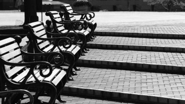 Meydanın kademeli basamaklarında sıralanan banklar